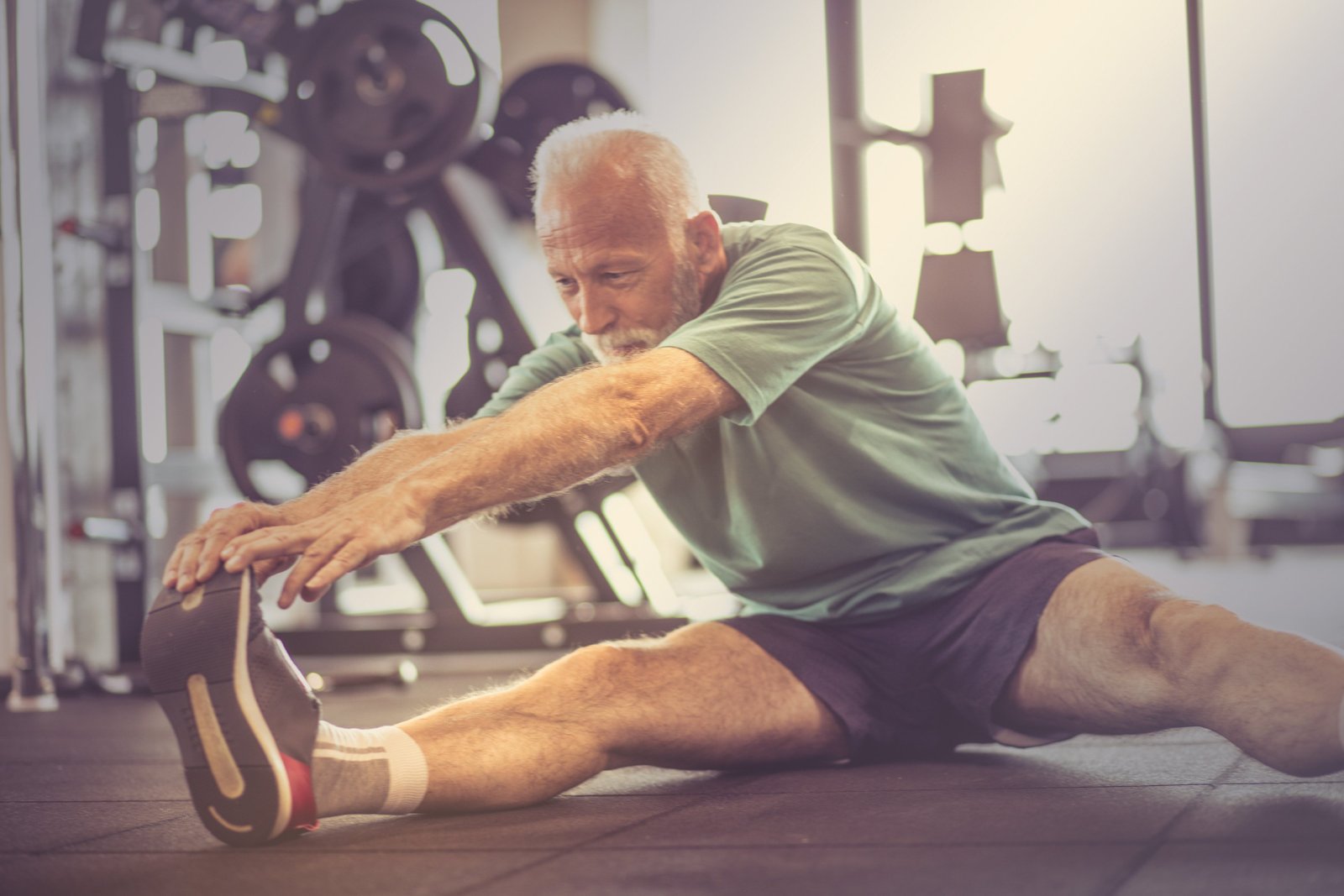 Mann dehnt sich im Fitnessstudio