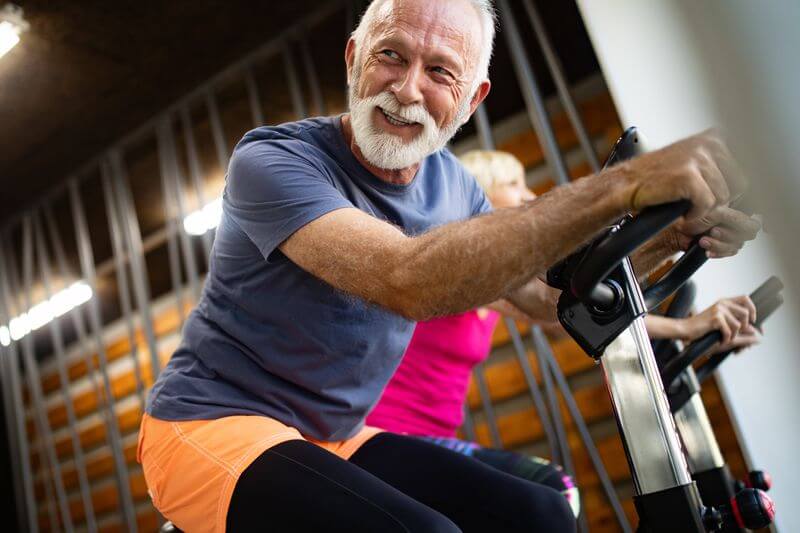 Mann trainiert auf dem Ergometer